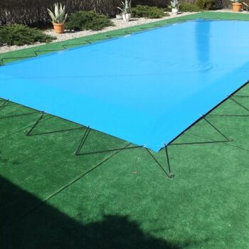 Die Winterabdeckung / Pool-Planen-Abdeckung 580g/m² mit hochfrequent geschweißten Ösen oder mit Keder deckt den Pool dicht ab und schafft in Kombination mit grünem Kunstrasen und Topfpflanzen eine ruhige Garten- oder Hinterhofatmosphäre.